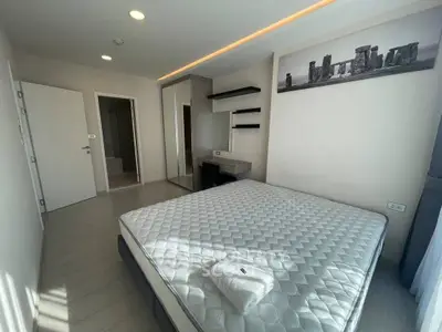 Modern bedroom with minimalist decor and large window for natural light.