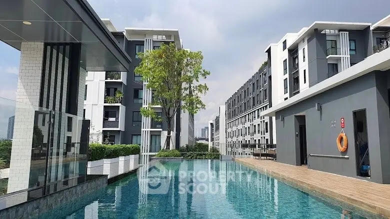 Luxurious modern apartment complex with stunning pool and sleek architecture.