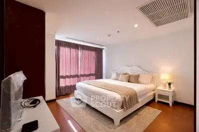 Elegant bedroom with cozy decor and natural light, featuring a plush bed and stylish furnishings.