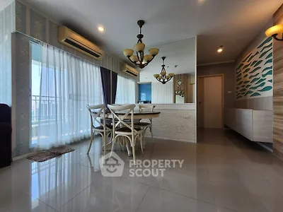Spacious modern living room with elegant dining area and large windows offering city views.