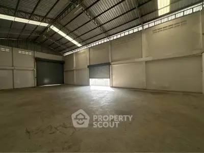 Spacious industrial warehouse with high ceilings and large roller doors