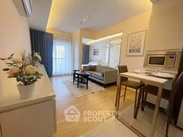 Modern living room with stylish decor and open layout, featuring cozy seating and elegant lighting.