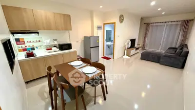 Spacious open-plan living room and kitchen with modern furnishings and ample natural light.
