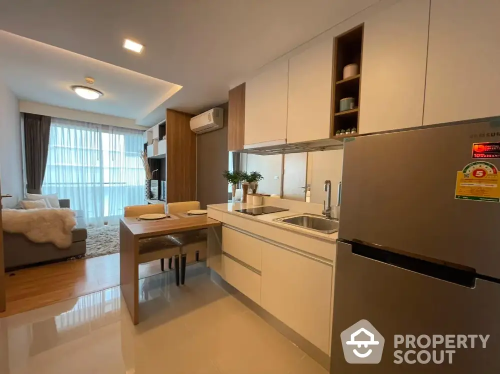 Modern open-layout kitchen and living room with sleek design and ample natural light.