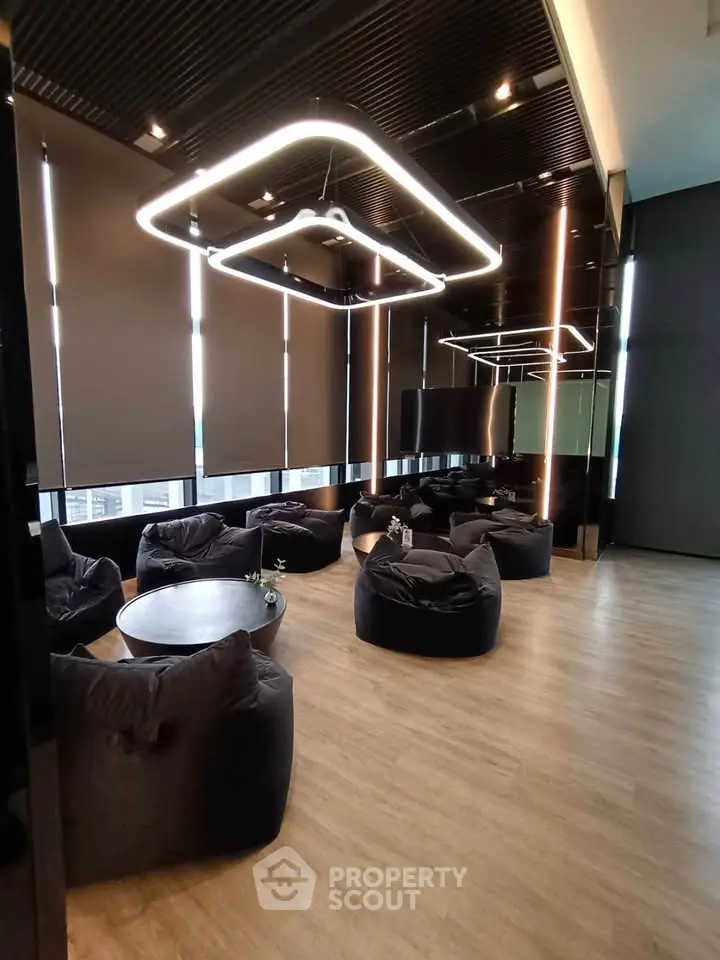 Modern co-working space with stylish lighting and comfortable seating in a high-rise building.