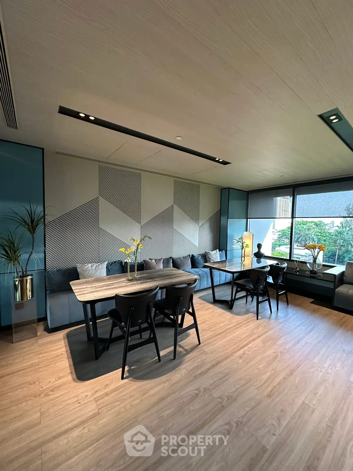 Modern living room with stylish decor and large windows offering natural light and garden view.