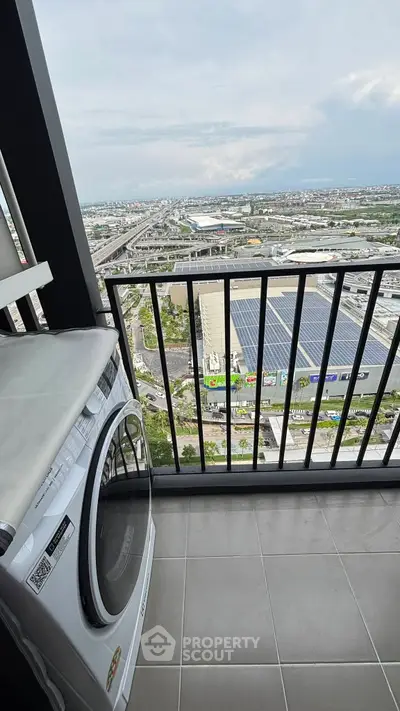 Stunning balcony view with washing machine overlooking cityscape and highway.