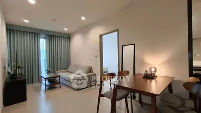 Modern living room with dining area, featuring stylish furniture and soft lighting for a cozy ambiance.