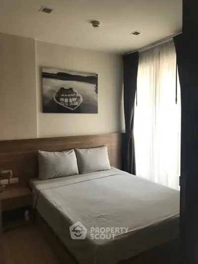 Cozy bedroom with natural light and modern decor in a stylish apartment.