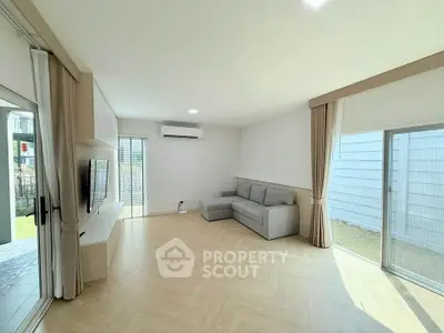 Spacious modern living room with large windows and stylish gray sofa