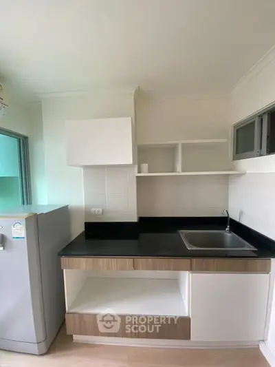 Modern kitchen with sleek cabinetry and stainless steel fridge