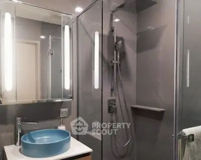 Modern bathroom with sleek design and blue basin in contemporary apartment.