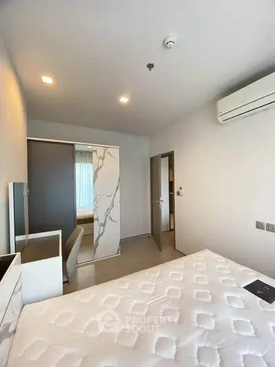 Modern bedroom with stylish decor and air conditioning in a contemporary apartment.
