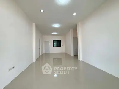 Spacious minimalist living room with glossy tiled floors and recessed lighting