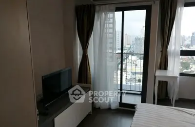 Modern bedroom with city view and balcony access in high-rise apartment