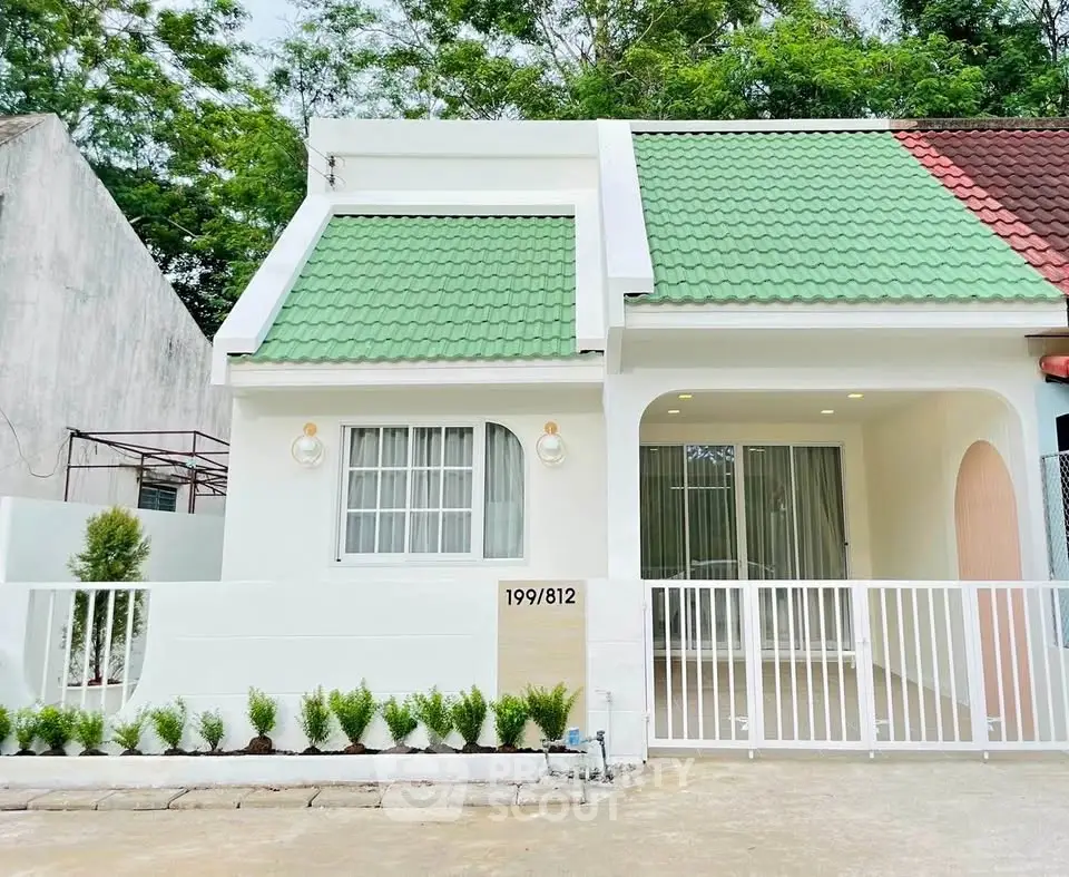 Charming single-story home with green roof and modern facade, perfect for cozy living.