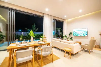 Luxurious open-plan living room with elegant dining area and poolside view.