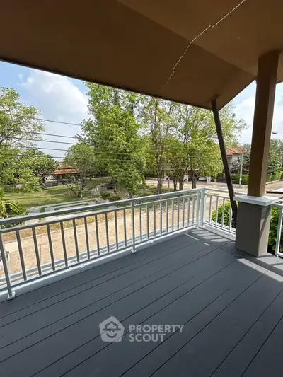 Spacious balcony with scenic view of lush greenery and serene neighborhood.