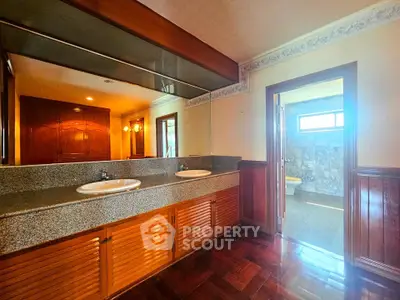 Spacious bathroom with dual sinks and elegant wooden cabinetry