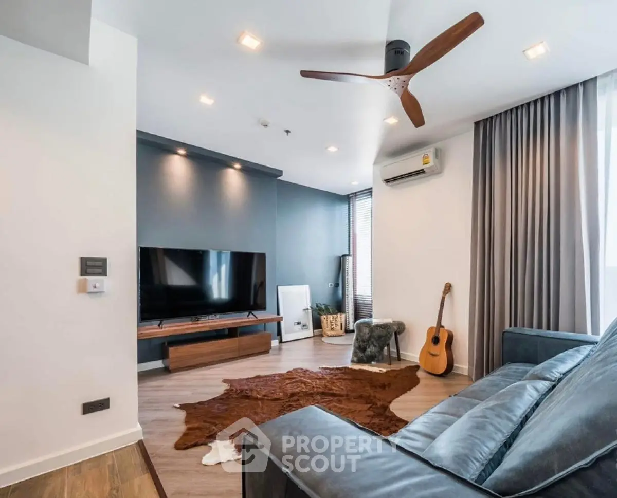 Modern living room with stylish decor, featuring a sleek TV setup and cozy seating area.