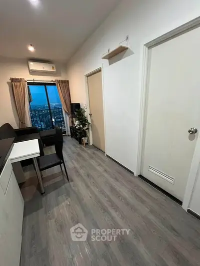 Modern apartment interior with city view, featuring sleek flooring and stylish furniture.