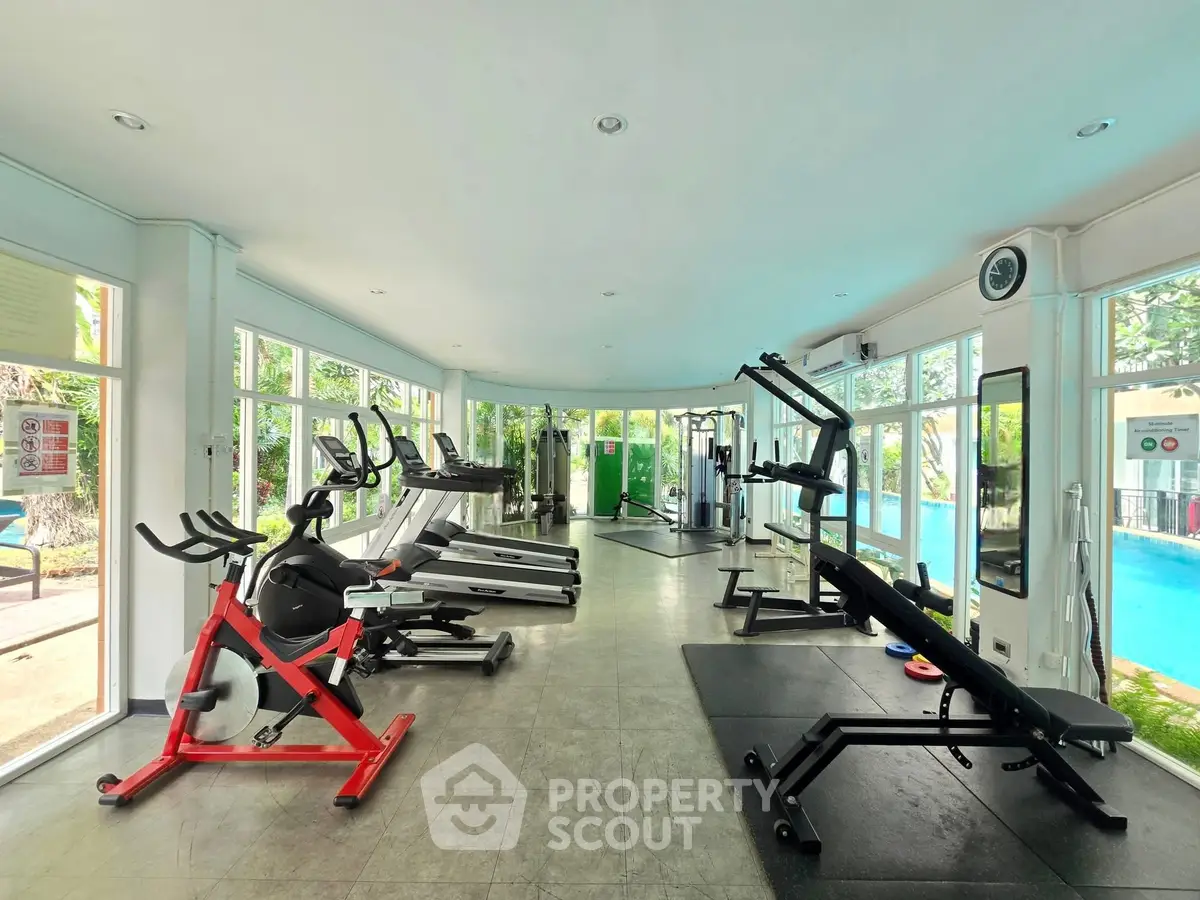 Spacious modern gym with pool view in luxury real estate property