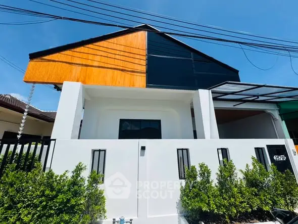 Modern two-story house with unique facade and lush greenery