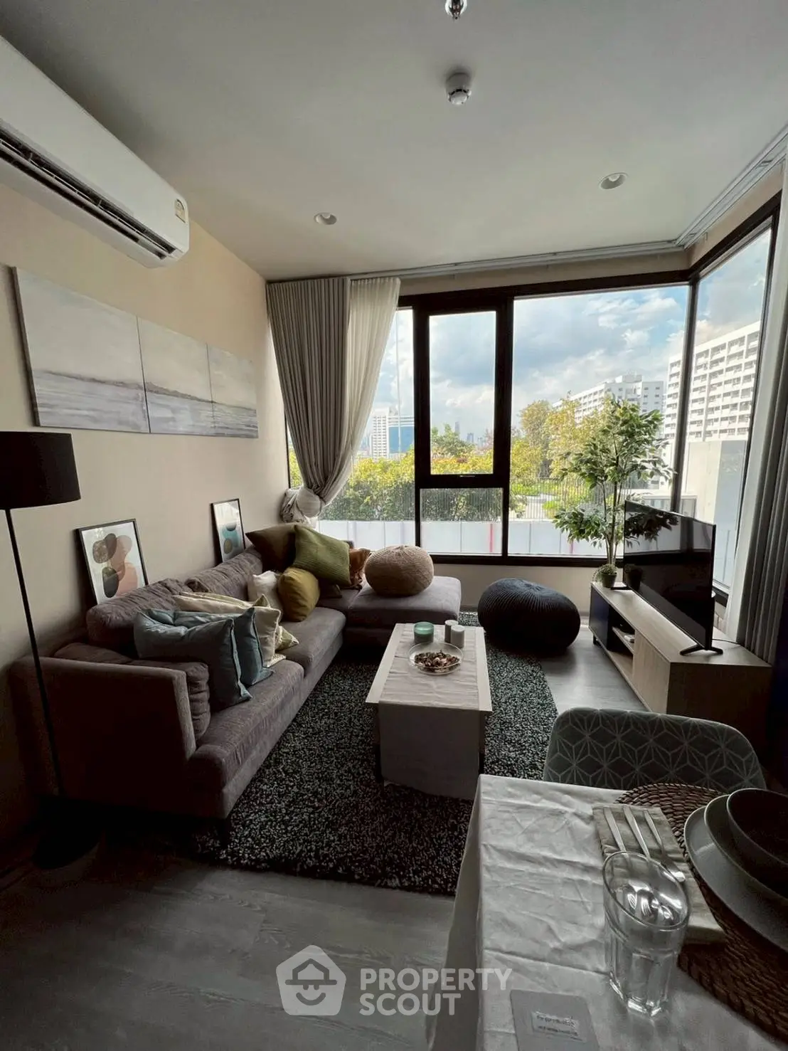 Modern living room with large windows and stylish decor in urban apartment