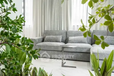 Stylish living room with modern gray sofa and lush indoor plants
