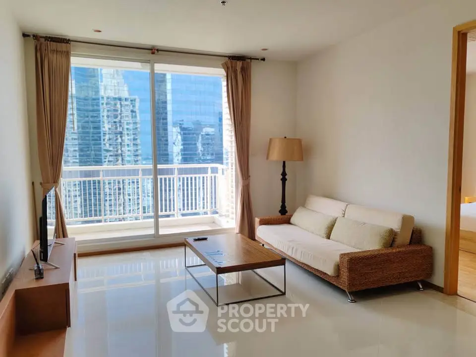 Spacious living room with modern furniture and stunning city view from large windows.