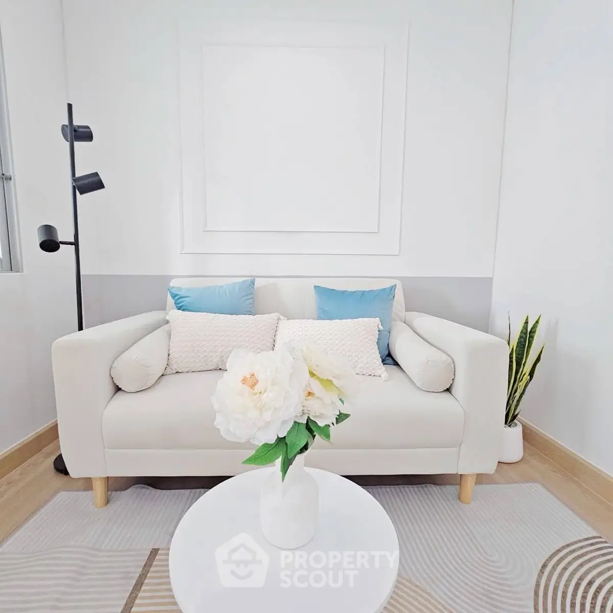 Chic modern living room with cozy white sofa and stylish decor accents.