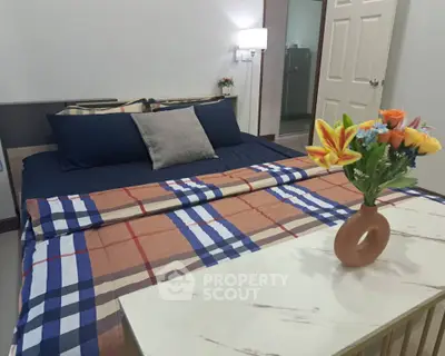 Cozy bedroom with stylish bedding and floral decor, perfect for relaxation.