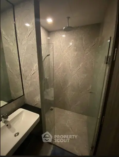 Luxurious modern bathroom with marble walls and sleek shower design.