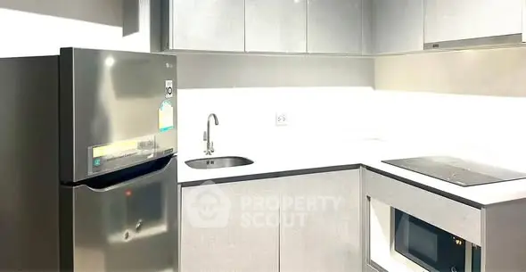 Modern kitchen with sleek appliances and minimalist design in a contemporary apartment.