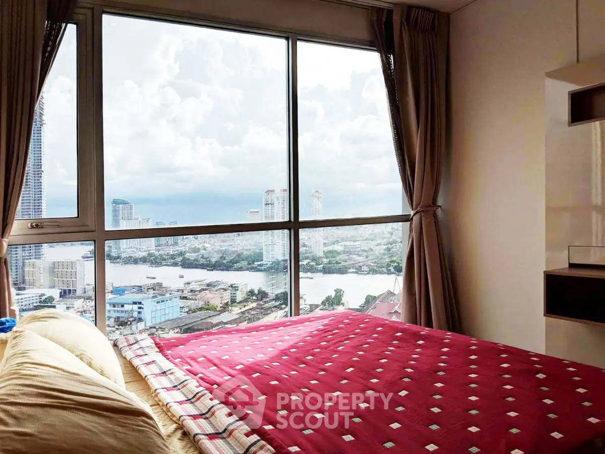 Stunning bedroom with panoramic city and river views, featuring large windows and cozy bedding.