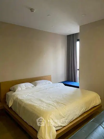 Spacious bedroom with modern design and large window for natural light.