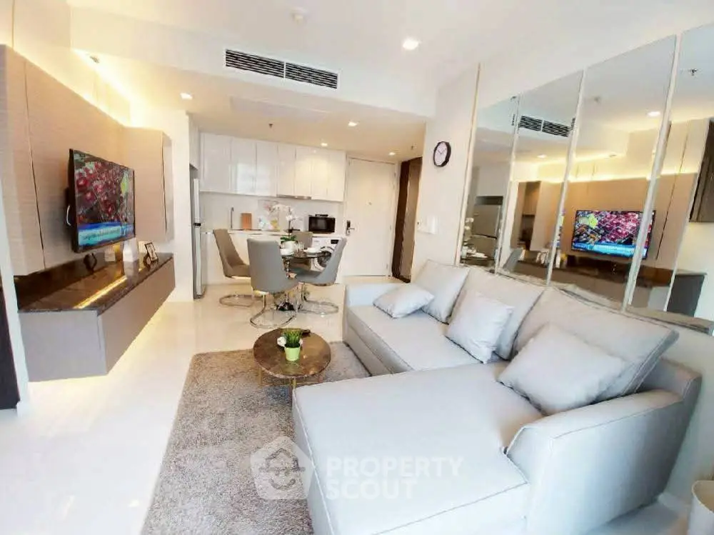 Modern living room with sleek furniture and open kitchen layout in a stylish apartment.