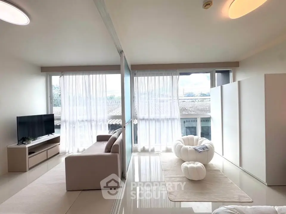 Modern living room with stylish furniture and large windows offering natural light and scenic views.
