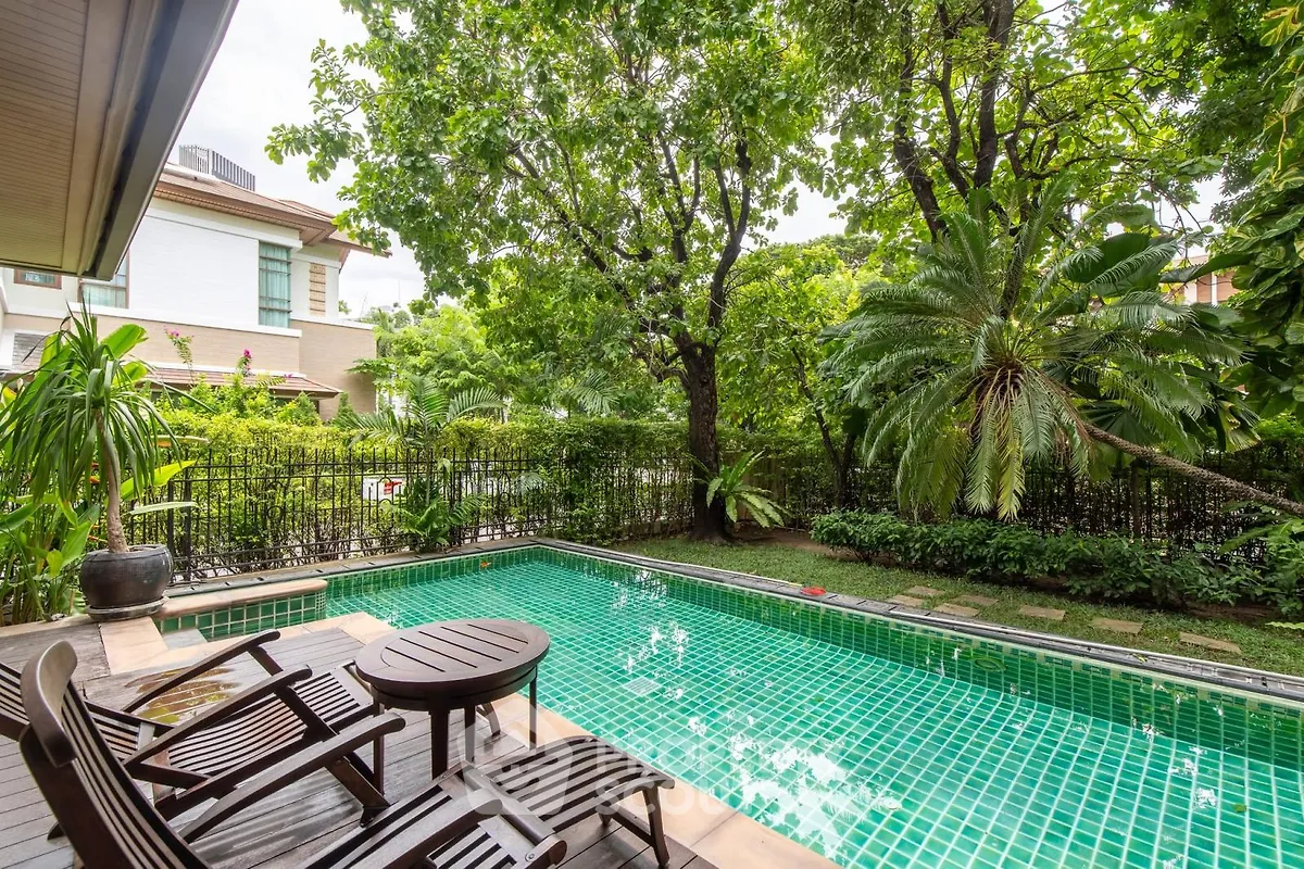 Luxurious private pool surrounded by lush greenery in a serene residential setting.