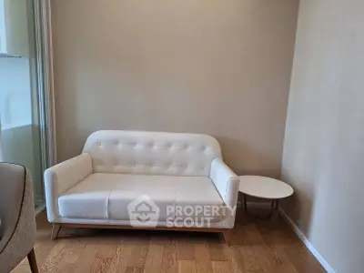 Modern living room with elegant white sofa and wooden flooring, perfect for cozy relaxation.