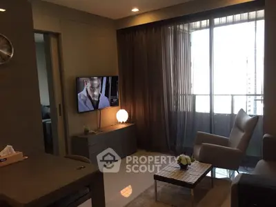 Modern living room with sleek furniture and large window for natural light.