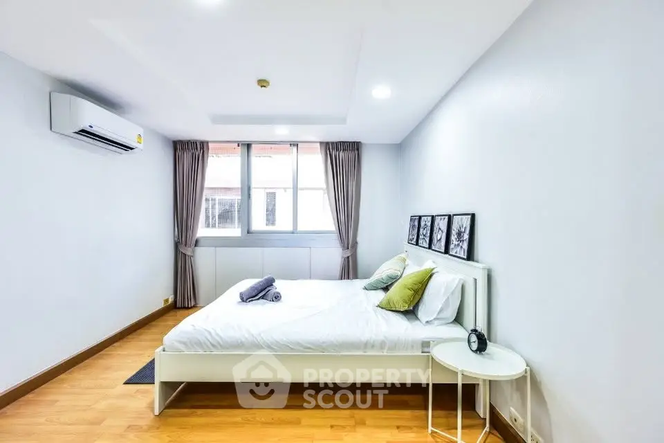 Spacious bedroom with modern decor and natural light in a stylish apartment.
