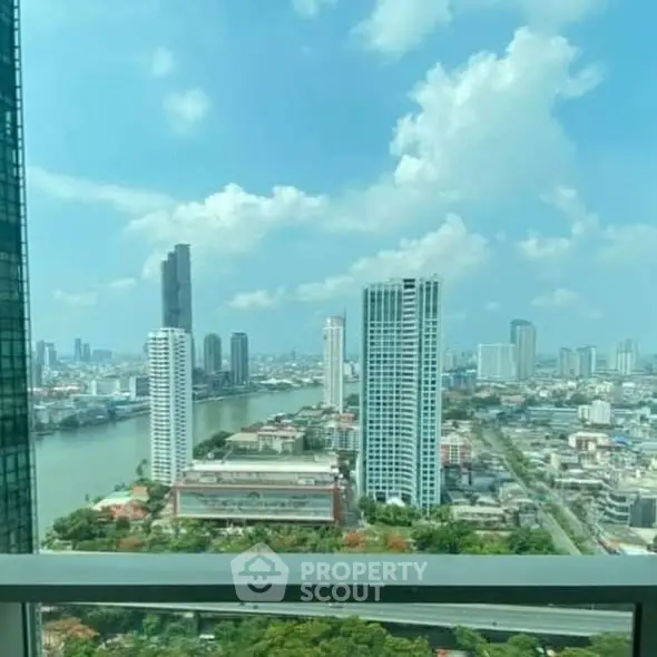 Stunning cityscape view from high-rise balcony overlooking river and skyline.