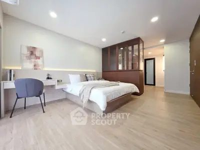 Spacious modern bedroom with elegant decor and wooden flooring