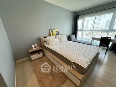 Modern bedroom with large window and city view, featuring stylish furniture and neutral decor.