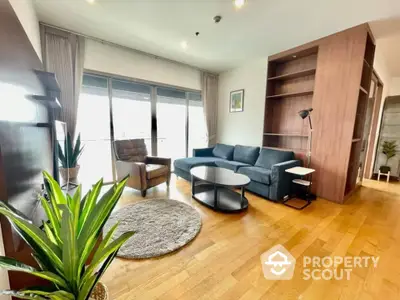 Spacious living room with hardwood floors, modern furniture, and ample natural light from floor-to-ceiling windows, perfect for urban living.