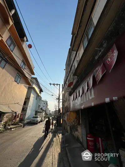 Charming urban street view with residential buildings and clear blue sky.