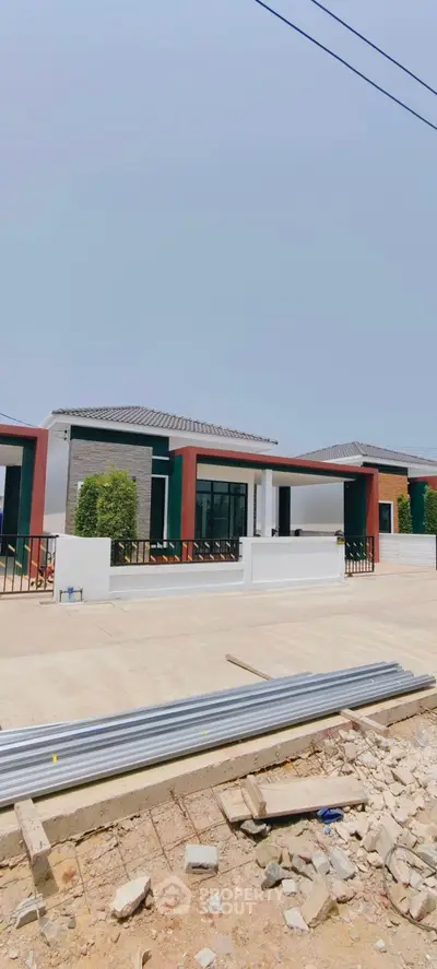 Modern single-story homes with sleek design and spacious driveways under clear blue skies.