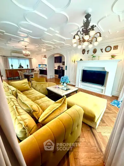 Luxurious living room with elegant decor, plush yellow sofa, and large TV, perfect for relaxation and entertainment.