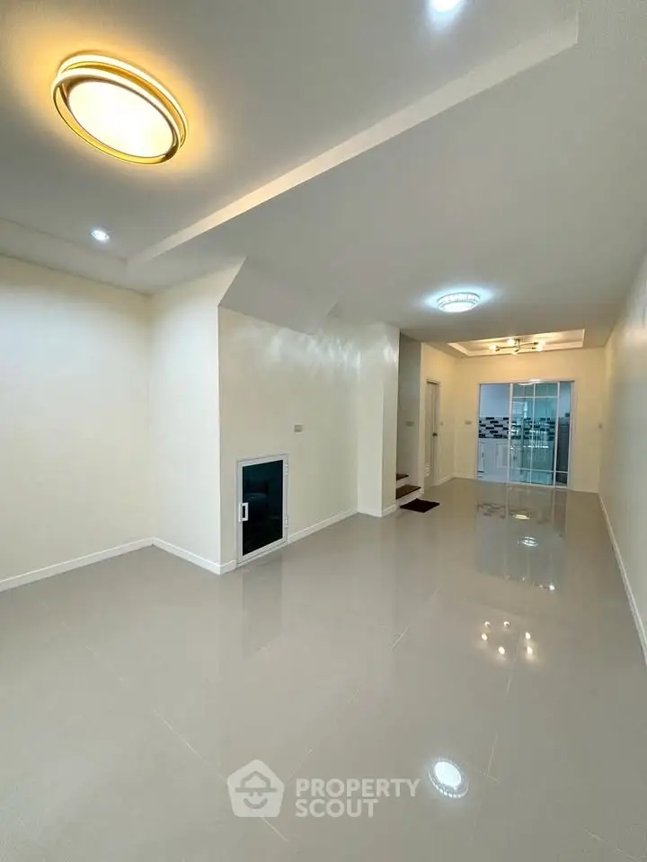 Spacious modern living room with sleek lighting and glossy floors